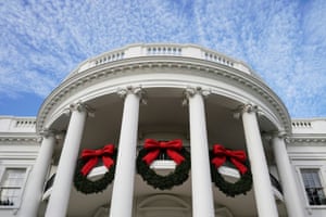 Christmas wreaths hang from the facade of the White House