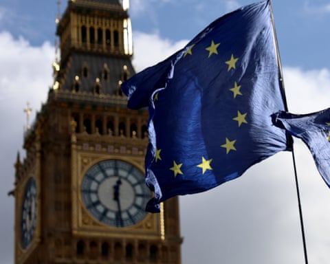 The EU flag flutters in the wind in the foreground of Big Ben in London