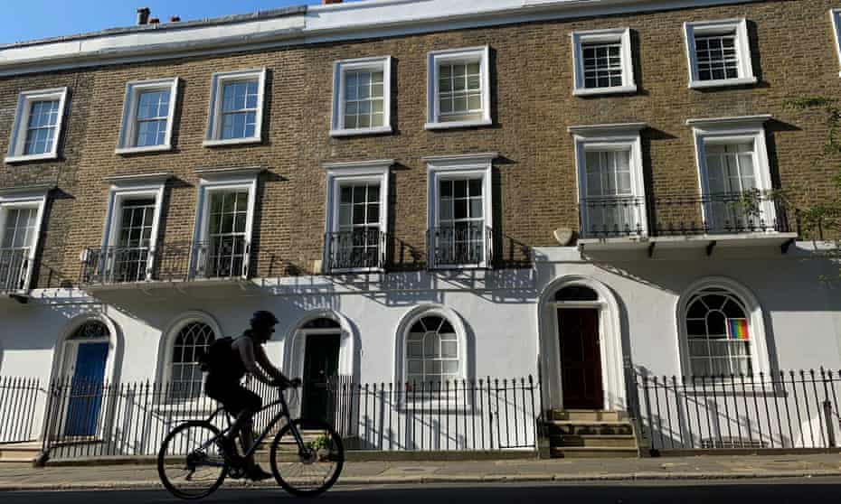 A cyclist rides past houses in Islington