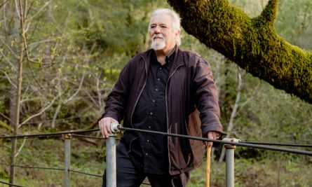 Breck Parkman looking out over a railing in a wood