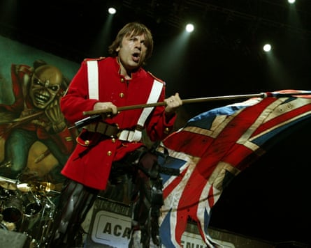 Dickinson in a red military-style jacket waving a union jack flag