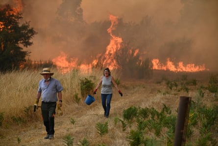 People try to battle a wildfire in the village of Santa Baia de Montes