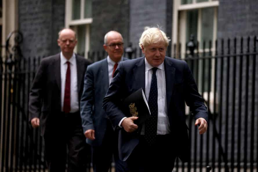 Boris Johnson (front), Patrick Vallance (centre) and Chris Whitty on their way to the press conference.