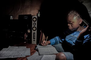 Marie studies at home by the light of a mobile phone