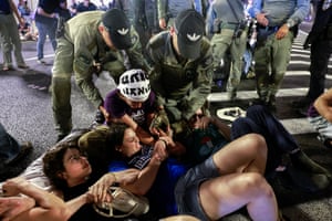 Israeli police reach down to lift up demonstrators lying on the ground