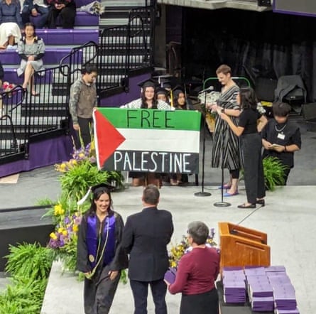 A stage with purple accents, and a woman holding a large Palestinian flag that say ‘Free Palestine.’