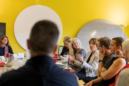 Airey speaking at a table of people