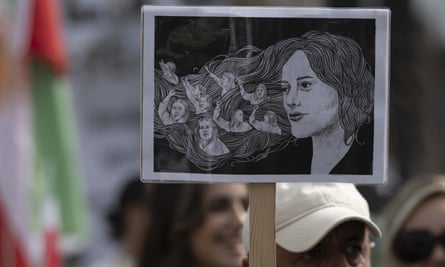A placard with a drawing of Mahsa Amini is held up by protesters in London