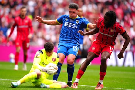 Walsall goalkeeper Tommy Simkin claims the ball from the feet of AFC Wimbledon’s Matty Stevens