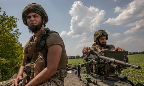 Members of the newly formed Ukrainian brigade, the 37th separate marines, on a tank in a field near the frontline.