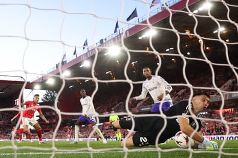 Aston Villa keeper Emiliano Martinez makes a save from Igor Jesus of Nottingham Forest (left).