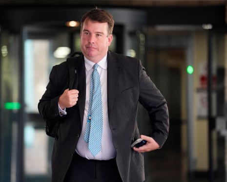 Craig Williams leaves Southwark crown court with its revolving glass doors in the background. He is in his early 40s and is plump with short, light brown hair. He wears a white shirt, pale blue tie and a dark jacket.