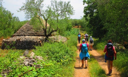 Walkers passing a trullo conical house