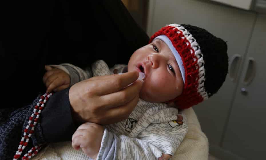 A health worker administers a polio vaccine on a child in Sana’a, Yemen.