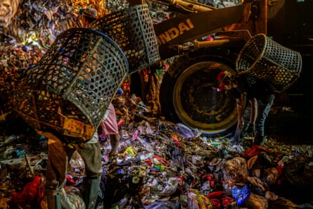 People sorting through huge piles of waste
