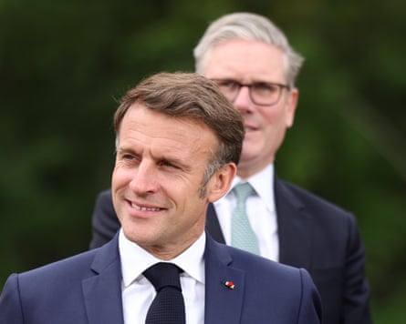 Emmanuel Macron smiles as he looks to the side
