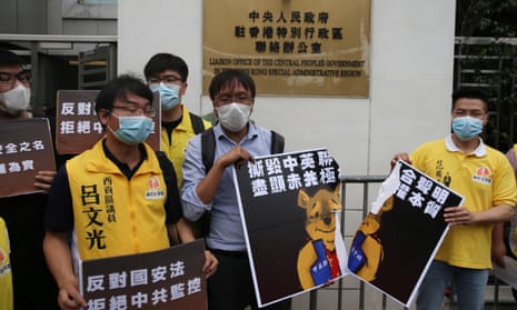 Local district councillors tear a poster depicting Winnie the Pooh tearing up the 1984 Sino-British Joint Declaration, during a protest against a newly proposed national security law outside the China Liaison Office in Hong Kong, China, 24 May 2020.