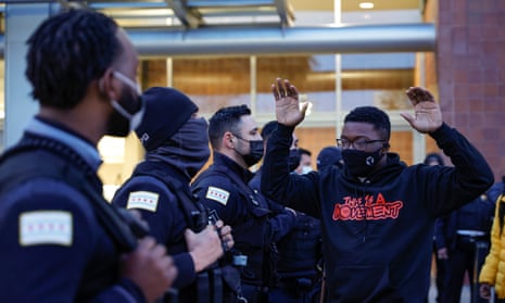 An activist holds his hands up outside Chicago police headquarters during a rally on 15 April. 