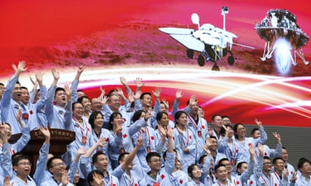 In this photo released by Xinhua News Agency, members at the Beijing Aerospace Control Center celebrate after China’s Tianwen-1 probe successfully landing on Mars.