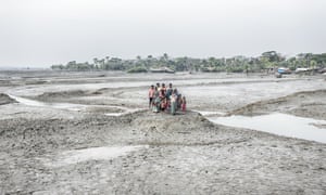Family stands together amid flooded landscape in Bangladesh