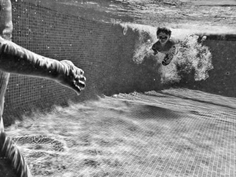 Black and white photo of a young boy learning to swim