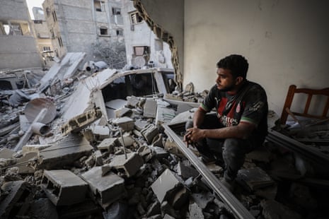 Man sits in shelled building surrounded by rubble in Gaza