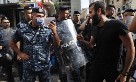 An anti-government protester shouts at riot police in Beirut on Friday, near the scene where a Lebanese man killed himself apparently because of the deteriorating economic and financial crisis.