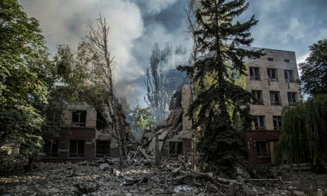 Smoke rises over the remains of a building destroyed by a Russian attack.