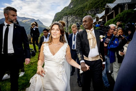 The couple walking hand-in-hand in their wedding attire