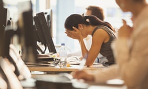 Stressed businesswoman with head in hands at office desk