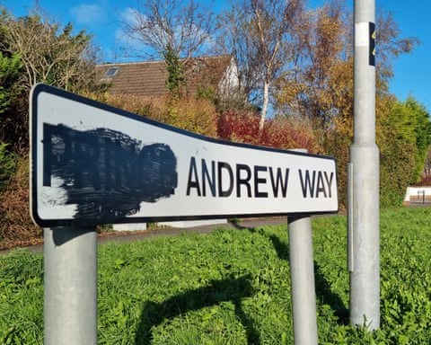 A sign on a grass verge for Prince Andrew Way, with the 'Prince' scribbled out'