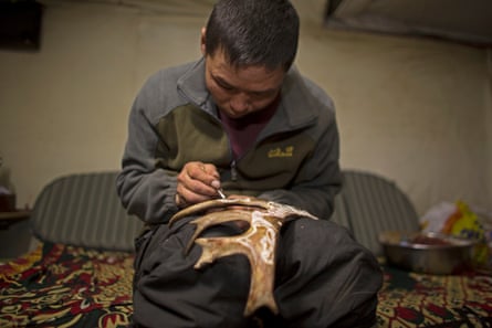 Oltsen decorates a piece of reindeer antler – the Dukha can make money from selling craftwork to tourists.