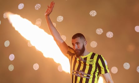 Karim Benzema waves to fans at his unveiling as an Al-Ittihad player.