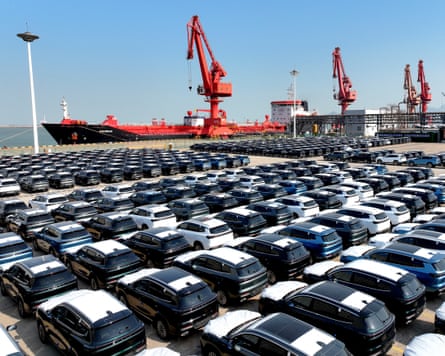 Chery cars for export are seen row after row withh ships in background