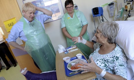 Boris Johnson speaking to patient Wenona Pappin, 70, during a visit to Torbay Hospital, south England, this afternoon.