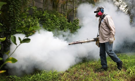 A Miami-Dade County mosquito control inspector, sprays pesticide to kill mosquitoes in Miami Beach, Florida.