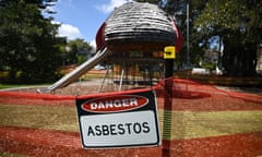 Danger asbestos sign hangs in from of playground with slide