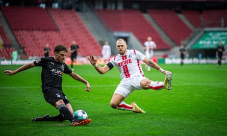 Jonas Hofmann (left) of Mönchengladbach tries to slide a cross past Rafael Czichos of Köln.