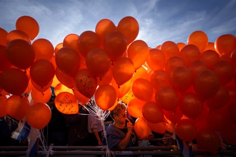 Los manifestantes sostienen globos naranjas en una manifestación de solidaridad con Kfir Bibas, un niño israelí que pasó su primer cumpleaños el jueves en cautiverio de Hamas en la Franja de Gaza, en Tel Aviv, Israel.