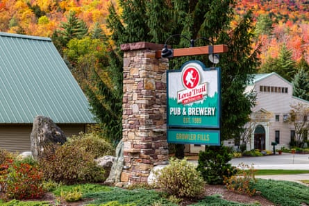 A motion – saying 'Long Trail Brewing Co Pub & Brewery Est 1989 Growler Fills – hangs extracurricular a building surrounded by lush vegetation pinch autumn colors