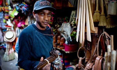 A trader holds up pods of fresh vanilla at a market in Antananarivo.