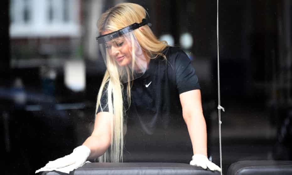 Stephanie Chrysostomou wears PPE as she cleans her beauty salon, Imagination, in north London on Friday.