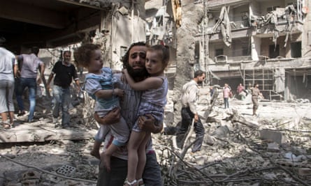 A man carries his two girls after barrel bomb attack  in Aleppo Syria.