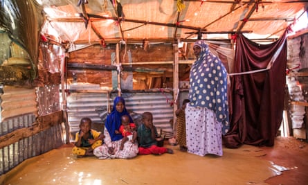 Malyaun Osman Omar (standing) with her daughter Khadro Abdullah and grandchildren at the Degaan IDP camp.