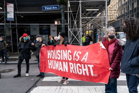 people hold sign that says ‘housing is a human right’