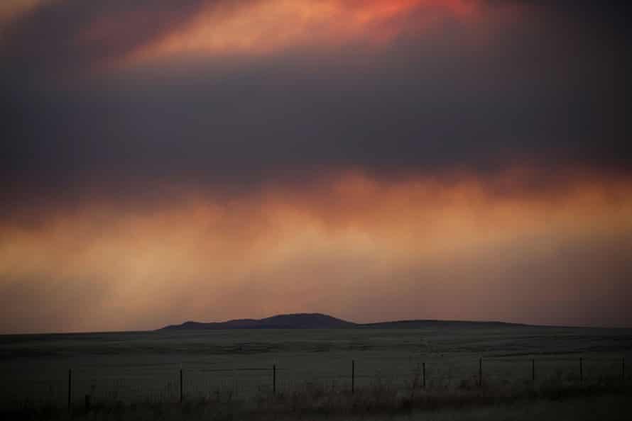 A general view of the landscape with plumes of smoke from the Hermits peak and Calf Canyon fires filling the sky in New Mexico.