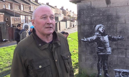 Man standing in front of a Banksy