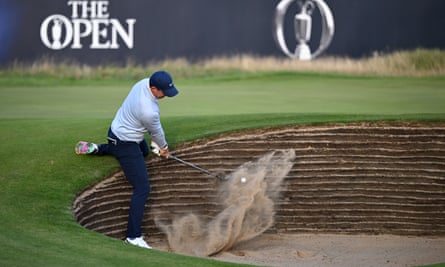 Rory McIlroy plays a shot from a bunker on the 18th hole.