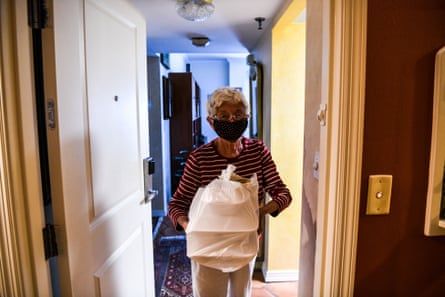 Charlie Aron, 84, wears a mask as she receives her food delivery in John Knox Village on 7 August. About 900 retirees live in the South Florida senior community.