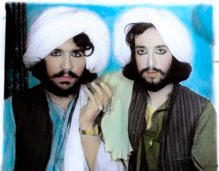 Photograph of two men in traditional Afghan dress holding hands